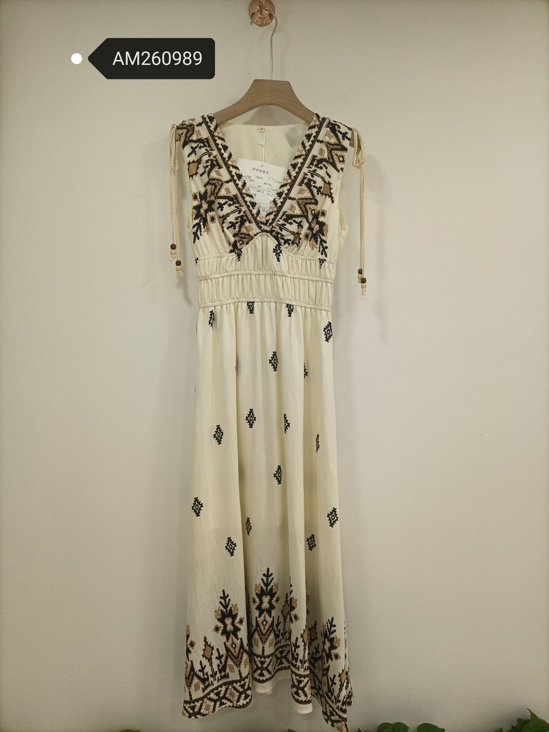 Embroidered Empire Waist Maxi Dress in cream. Detailed front flat lay view highlighting the overall silhouette. B2B wholesale Dresses SKU: AM260989.