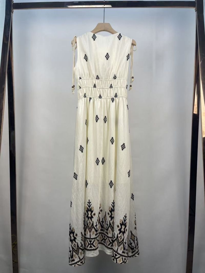 Embroidered Empire Waist Maxi Dress in cream. Macro close-up view focusing on the contrasting geometric embroidered hem. B2B wholesale Dresses SKU: AM260989.