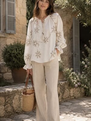 Floral Tassel-Tie Blouse in ivory with taupe floral motifs. Lifestyle model shot showcasing the fit and drape. B2B wholesale Blouses & Tops SKU: AM25386.