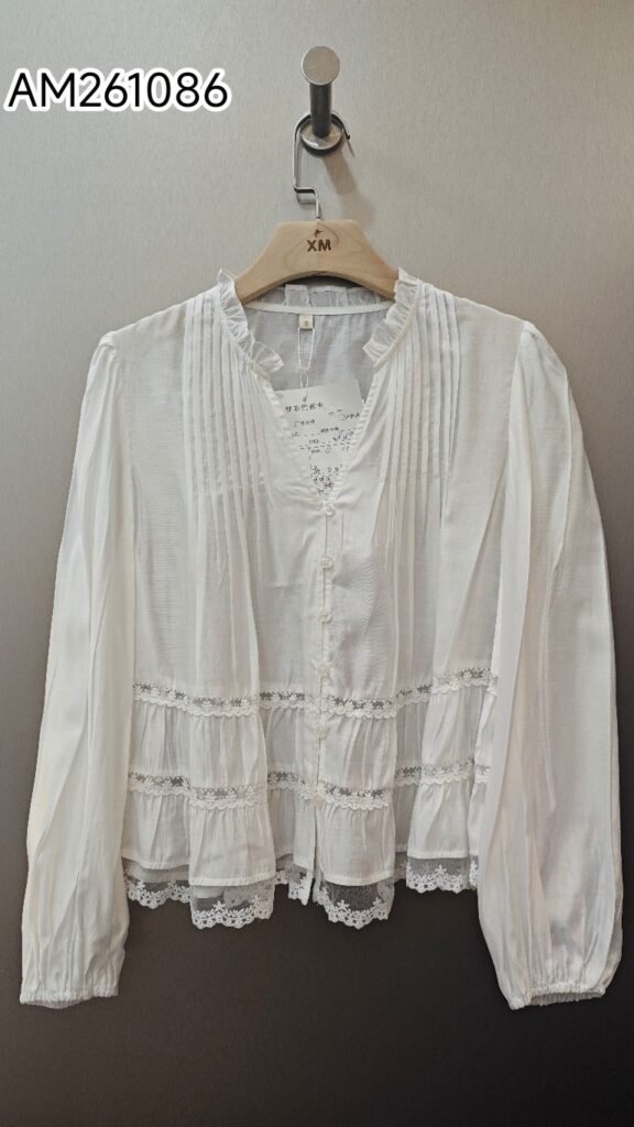 White Tiered Ruffle Collar Blouse in white. Detailed front flat lay view highlighting the overall silhouette. B2B wholesale Blouses & Tops SKU: AM261086.